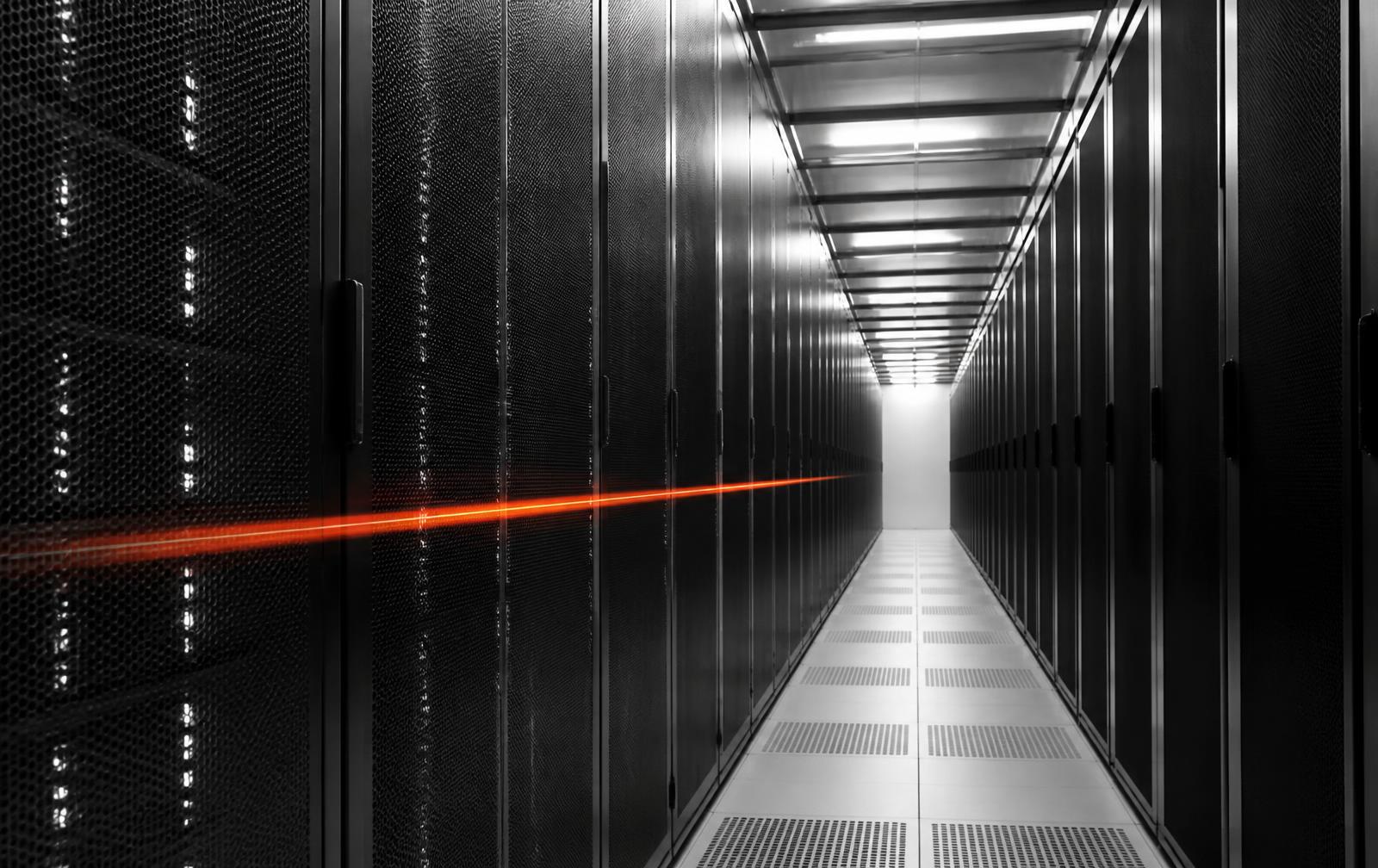 Corridor of server racks lit along its length inside a data centre