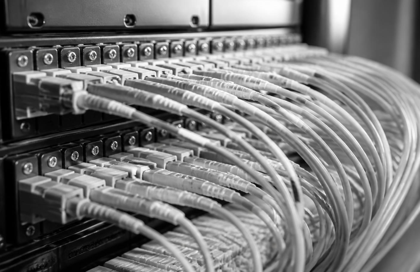 Close view of ordered fibre optic patch cables connected to a network panel